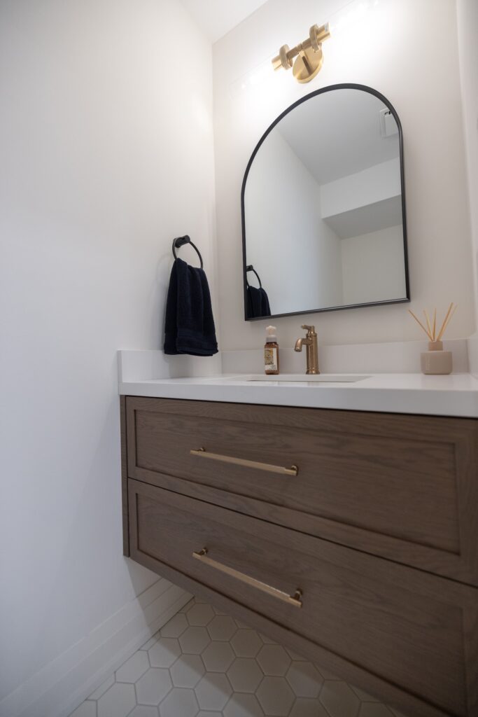 Renovated bathroom with arched mirror