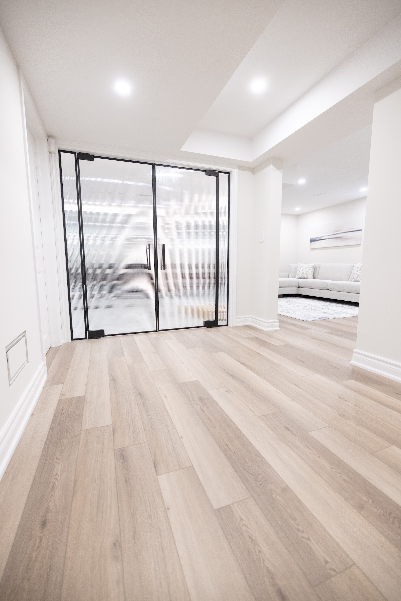 Black framed reeded glass sliding partition doors in a finished basement, Hamilton
