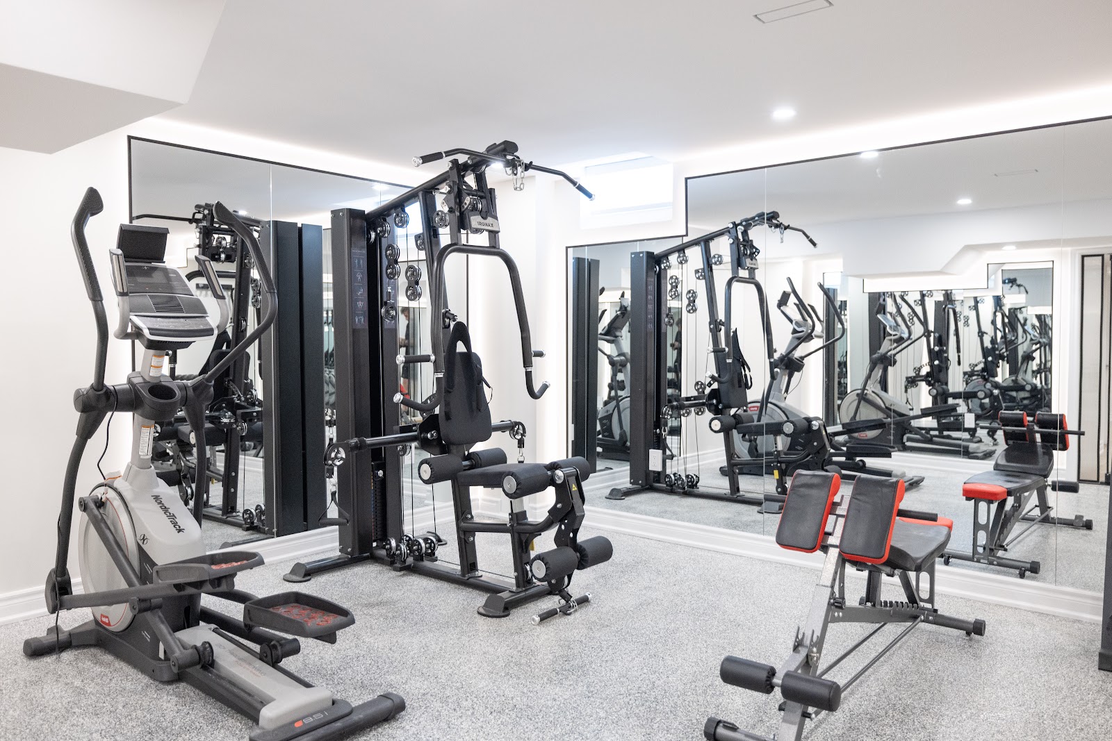 Finished basement home gym with exercise equipment and mirrored wall, Hamilton renovation