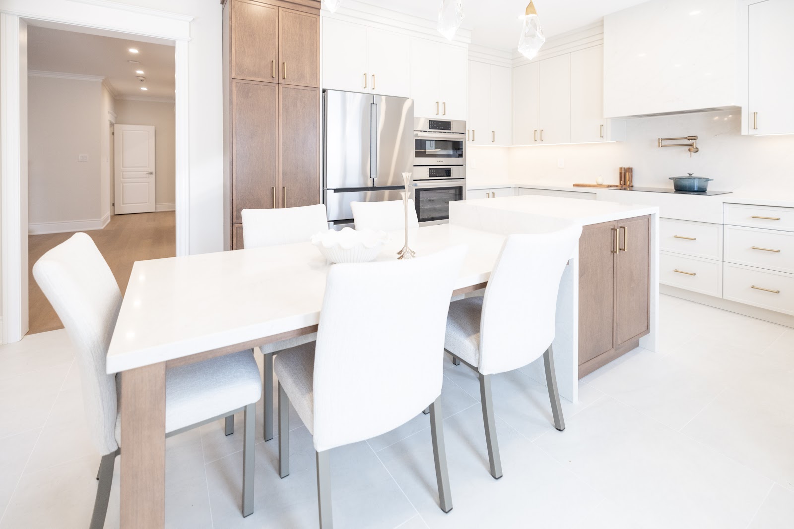 Renovated open-concept kitchen with white quartz island, dining table and stainless appliances, Hamilton home renovation by Final Touch Contract